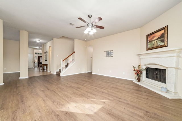 21739 W Mulberry Field Cir, Cypress, TX 77433 - unfurnished living room with arched walkways, ceiling fan, wood finished floors, and stairs