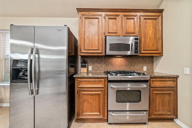 21739 W Mulberry Field Cir, Cypress, TX 77433 - kitchen with appliances with stainless steel finishes, backsplash, light tile patterned floors, and brown cabinetry