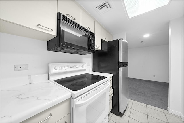 3525 Sage Rd Unit 813, Houston, TX 77056 - kitchen with white electric range, black microwave, light carpet, white cabinetry, and light tile patterned floors