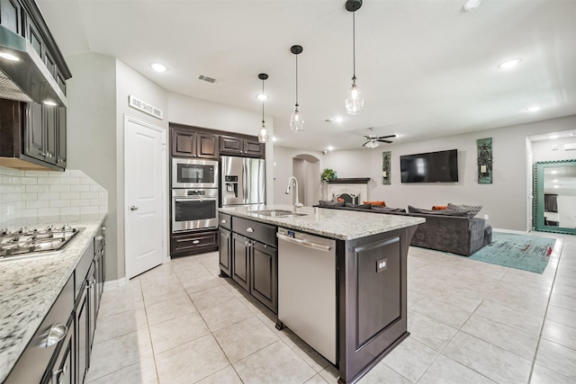 30806 Meadow Wood Dr, Fulshear, TX 77441 - kitchen featuring appliances with stainless steel finishes, arched walkways, a ceiling fan, light tile patterned flooring, and recessed lighting