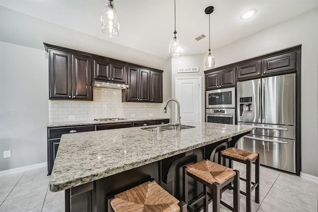 30806 Meadow Wood Dr, Fulshear, TX 77441 - kitchen with appliances with stainless steel finishes, light tile patterned floors, backsplash, and a kitchen bar