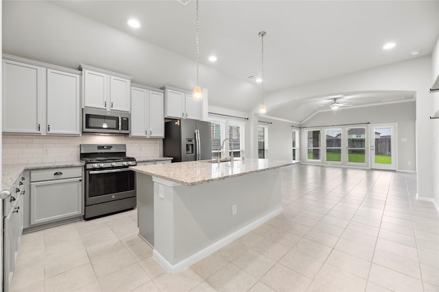 31222 S Pinebrook Falls Ln S, Hockley, TX 77447 - kitchen featuring stainless steel appliances, vaulted ceiling, ceiling fan, open floor plan, and tasteful backsplash