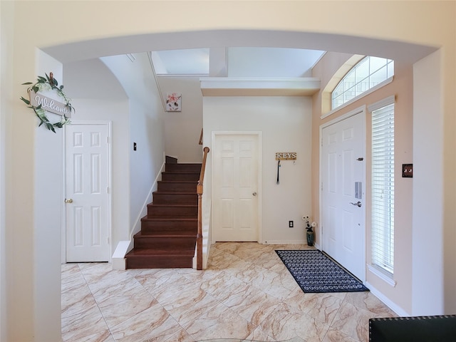 11811 Champions Grove Ln, Houston, TX 77066 - foyer entrance with marble look tile flooring, arched walkways, plenty of natural light, and stairway