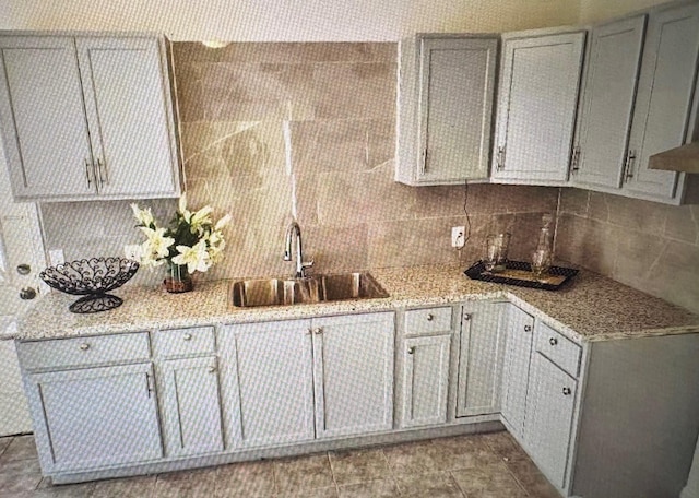 7005 Kassarine Pass, Houston, TX 77033 - kitchen featuring tasteful backsplash, light stone countertops, and gray cabinets