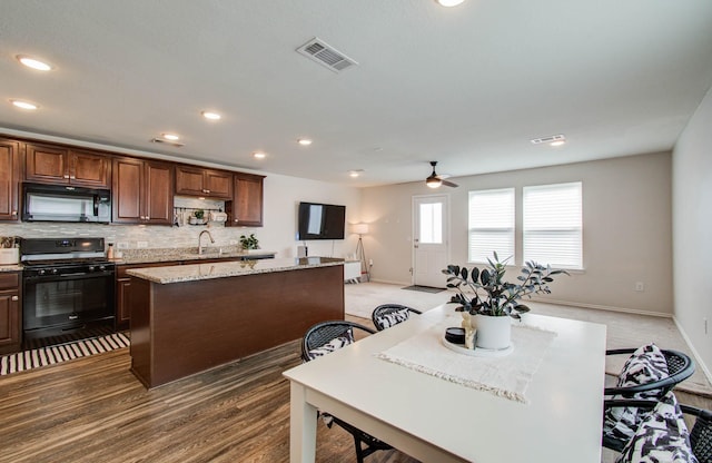 14746 Jasper Stream Ct, Houston, TX 77069 - kitchen featuring black appliances, a kitchen island, ceiling fan, backsplash, and recessed lighting