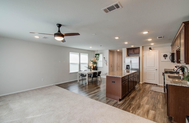 14746 Jasper Stream Ct, Houston, TX 77069 - kitchen with stainless steel appliances, a kitchen island, a ceiling fan, dark brown cabinetry, and recessed lighting