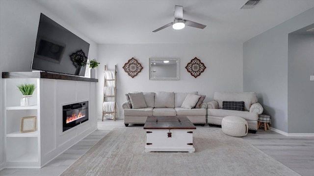 2608 Bering Dr Unit 2608, Houston, TX 77057 - living room with a ceiling fan, wood finished floors, and a glass covered fireplace