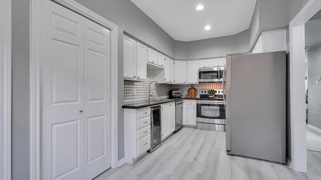 2608 Bering Dr Unit 2608, Houston, TX 77057 - kitchen with appliances with stainless steel finishes, dark countertops, wine cooler, white cabinets, and recessed lighting