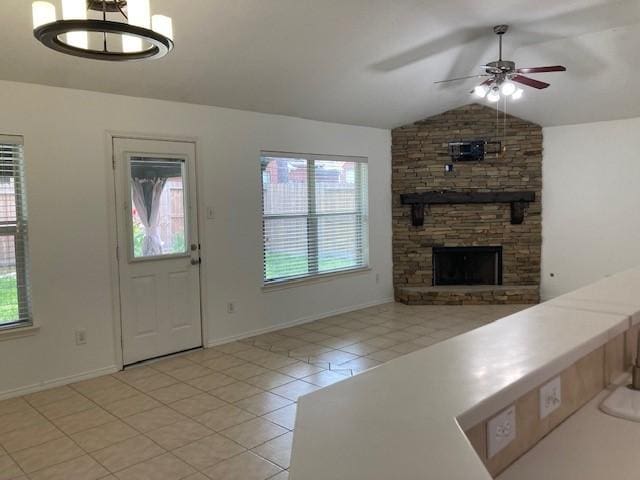 14007 Blackfoot Trail Run, Cypress, TX 77429 - unfurnished living room with light tile patterned floors, a ceiling fan, plenty of natural light, vaulted ceiling, and a stone fireplace