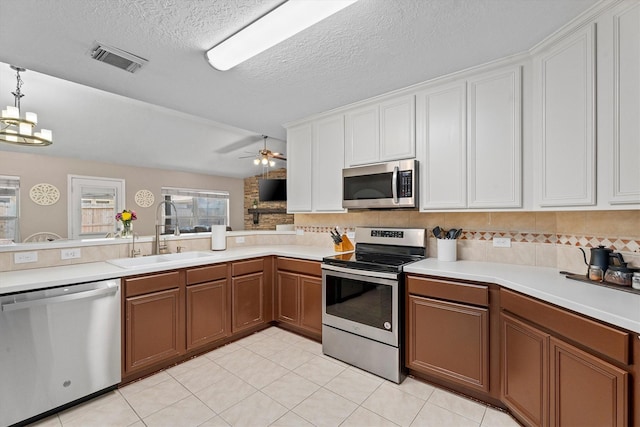 14007 Blackfoot Trail Run, Cypress, TX 77429 - kitchen with stainless steel appliances, light countertops, decorative backsplash, light tile patterned flooring, and white cabinetry