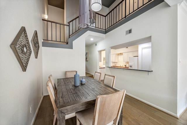 1228 Fountain View Dr Unit 180, Houston, TX 77057 - dining room featuring a towering ceiling, hardwood / wood-style floors, and stairway