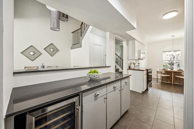 1228 Fountain View Dr Unit 180, Houston, TX 77057 - bar area featuring electric range, stairs, beverage cooler, white microwave, and dark tile patterned flooring