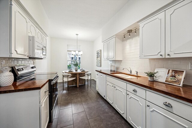 1228 Fountain View Dr Unit 180, Houston, TX 77057 - kitchen featuring wood counters, white appliances, tasteful backsplash, a chandelier, and white cabinets