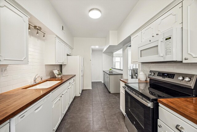 1228 Fountain View Dr Unit 180, Houston, TX 77057 - kitchen featuring white appliances, butcher block countertops, tasteful backsplash, and white cabinetry