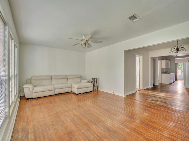1214 W 6th St, Freeport, TX 77541 - living area with light wood finished floors, a ceiling fan, and a chandelier