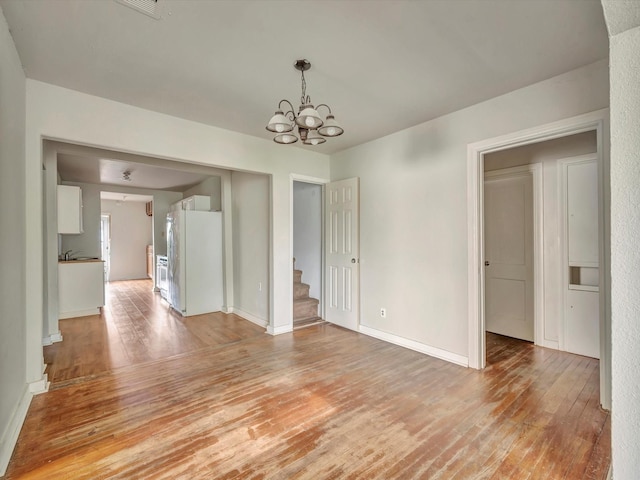 1214 W 6th St, Freeport, TX 77541 - unfurnished room featuring light wood-type flooring, a chandelier, and stairway