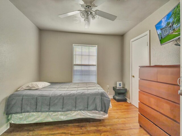 1214 W 6th St, Freeport, TX 77541 - bedroom with wood finished floors, ceiling fan, and a textured wall