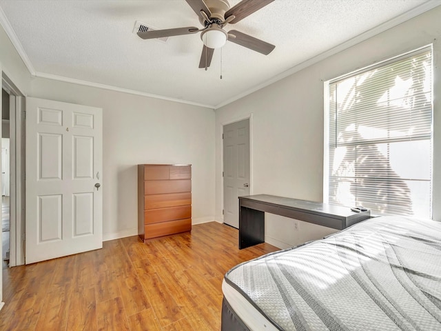 1214 W 6th St, Freeport, TX 77541 - bedroom with light wood-style flooring, crown molding, a textured ceiling, and a ceiling fan
