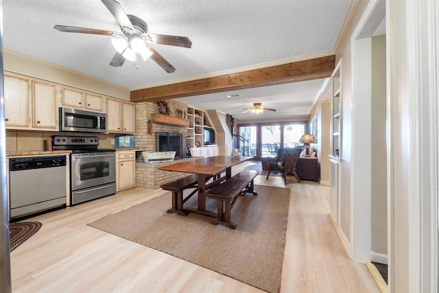 1831 Lakeview Estates Dr, Coldspring, TX 77331 - kitchen with appliances with stainless steel finishes, a ceiling fan, a fireplace, a textured ceiling, and light wood-style flooring