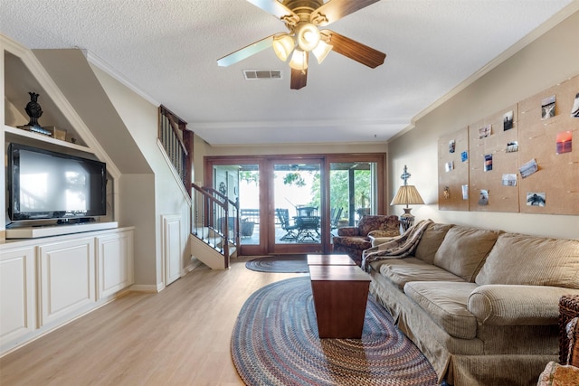 1831 Lakeview Estates Dr, Coldspring, TX 77331 - living area featuring stairway, light wood finished floors, ornamental molding, a ceiling fan, and a textured ceiling