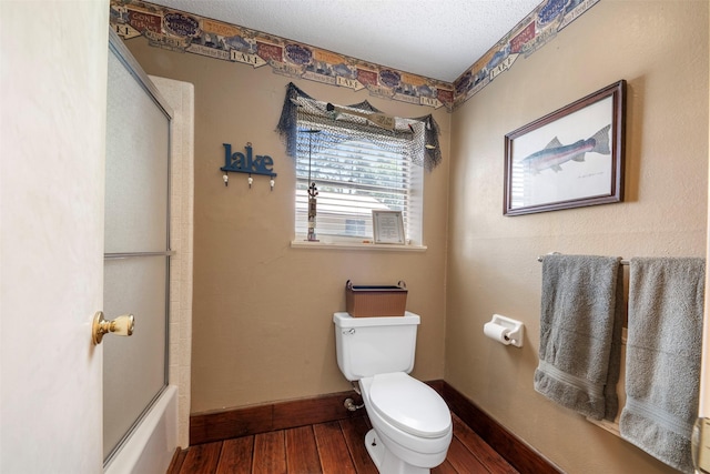 1831 Lakeview Estates Dr, Coldspring, TX 77331 - bathroom with hardwood / wood-style floors, shower / bath combination with glass door, and a textured ceiling