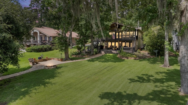 1831 Lakeview Estates Dr, Coldspring, TX 77331 - view of grassy yard with an outdoor fire pit, a deck, a patio area, and stairs