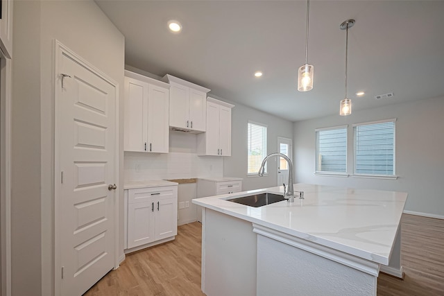14979 Eagle Feather Dr, Houston, TX 77090 - kitchen featuring light wood finished floors, a kitchen island with sink, white cabinets, and recessed lighting