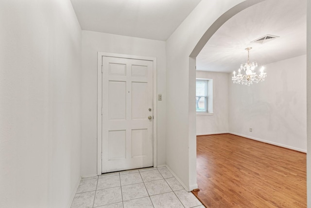 9622 Highmeadow Dr, Houston, TX 77063 - foyer featuring arched walkways, a chandelier, and light wood finished floors