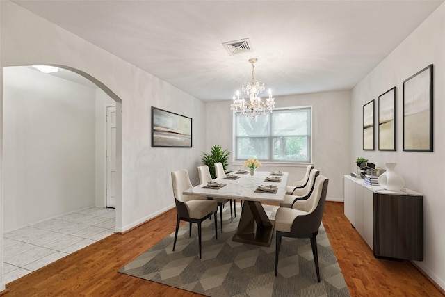 9622 Highmeadow Dr, Houston, TX 77063 - dining area with arched walkways, wood finished floors, and a chandelier