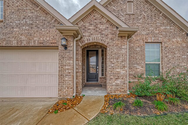 23722 Canolo Grove Ln, New Caney, TX 77357 - doorway to property featuring brick siding, a garage, and concrete driveway