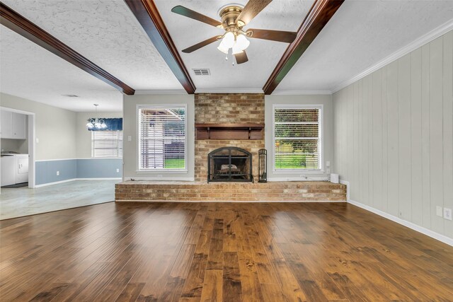 8115 Winding Oak Ln, Spring, TX 77379 - unfurnished living room featuring a fireplace, wood finished floors, beamed ceiling, healthy amount of natural light, and a chandelier