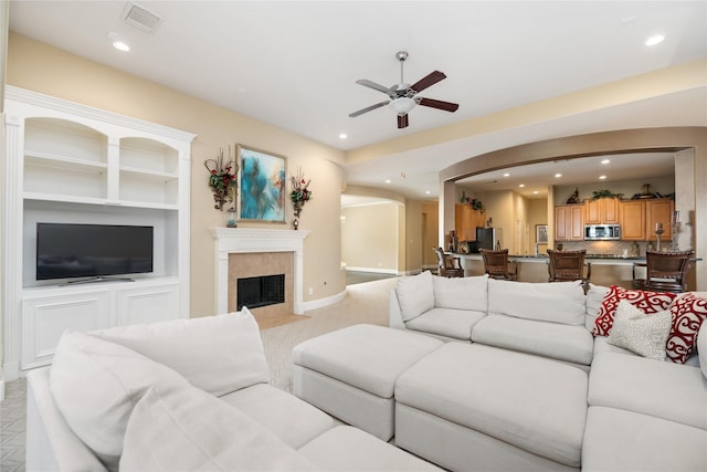 2010 Cias Trail Ln, Spring, TX 77386 - living room featuring a ceiling fan, arched walkways, recessed lighting, a tile fireplace, and built in features