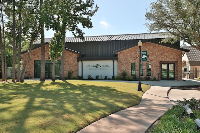 2010 Cias Trail Ln, Spring, TX 77386 - view of front facade featuring french doors, board and batten siding, stone siding, a front yard, and a standing seam roof