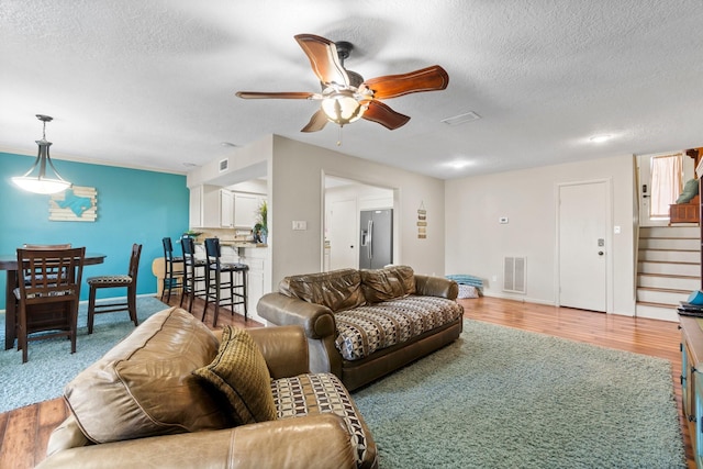 145 Capetown, Montgomery, TX 77356 - living room with a textured ceiling, ceiling fan, stairs, and wood finished floors