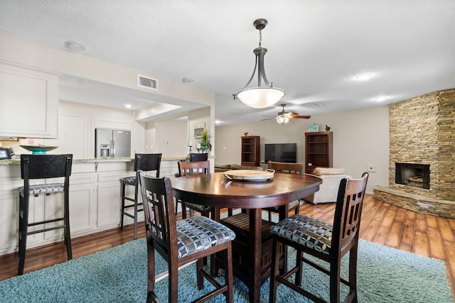 145 Capetown, Montgomery, TX 77356 - dining area with dark wood finished floors, a ceiling fan, and a fireplace