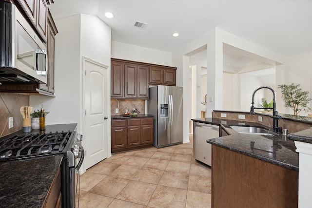 3112 Rock Brook Falls Ln, League City, TX 77573 - kitchen featuring appliances with stainless steel finishes, decorative backsplash, dark stone counters, and recessed lighting