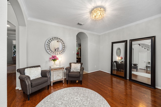 4402 Eden Point Ln, Katy, TX 77494 - sitting room featuring arched walkways, wood finished floors, a chandelier, ornamental molding, and a textured ceiling