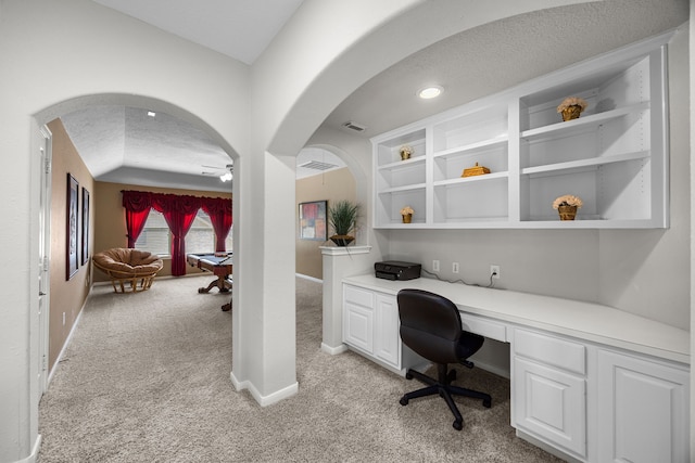 4402 Eden Point Ln, Katy, TX 77494 - office featuring light colored carpet, arched walkways, built in study area, a ceiling fan, and a textured ceiling