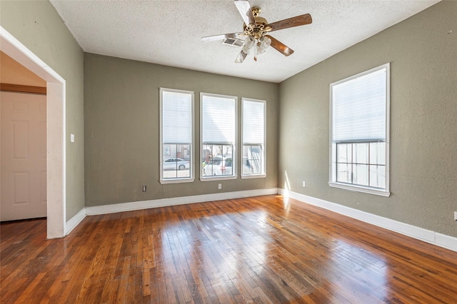 7609 Avenue Ave E, Houston, TX 77012 - empty room with plenty of natural light, a ceiling fan, wood-type flooring, and a textured ceiling