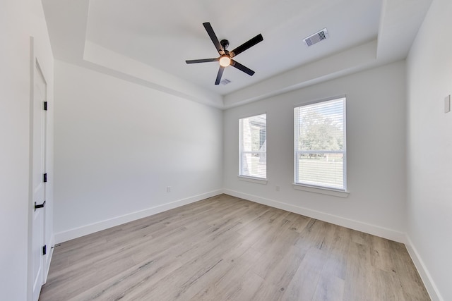 25050 Shady Oak Dr, Hockley, TX 77447 - spare room featuring light wood-style flooring, a ceiling fan, and a raised ceiling