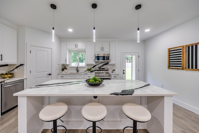 25050 Shady Oak Dr, Hockley, TX 77447 - kitchen featuring appliances with stainless steel finishes, light wood-style flooring, white cabinets, tasteful backsplash, and recessed lighting