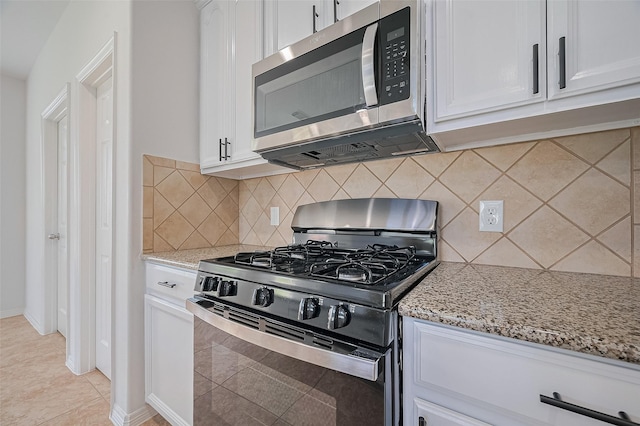4142 Regal Stone Ln, Sugar Land, TX 77479 - kitchen featuring gas stove, stainless steel microwave, light stone countertops, and white cabinetry