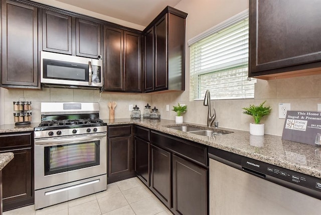 3514 Marquesa Ln, Houston, TX 77084 - kitchen featuring stainless steel appliances, light stone countertops, decorative backsplash, light tile patterned flooring, and dark brown cabinets