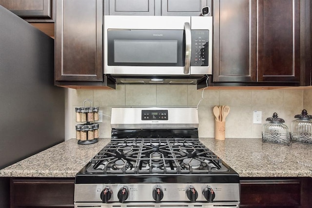 3514 Marquesa Ln, Houston, TX 77084 - kitchen with appliances with stainless steel finishes, dark brown cabinets, decorative backsplash, and light stone counters