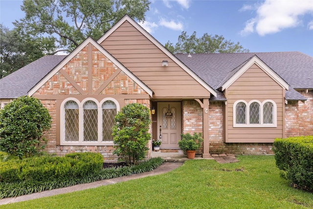 2006 Echo Ridge Ct, Houston, TX 77339 - tudor home with a shingled roof, a front lawn, and brick siding