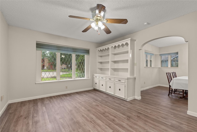 2006 Echo Ridge Ct, Houston, TX 77339 - empty room featuring wood finished floors, arched walkways, a ceiling fan, and a textured ceiling