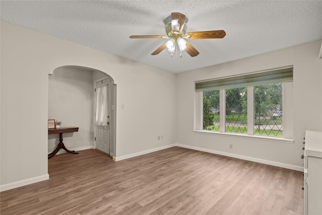 2006 Echo Ridge Ct, Houston, TX 77339 - empty room featuring arched walkways, wood finished floors, ceiling fan, and a textured ceiling