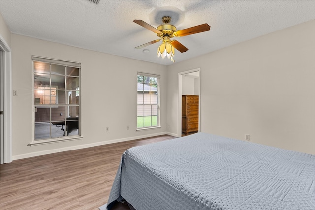 2006 Echo Ridge Ct, Houston, TX 77339 - bedroom featuring wood finished floors, ceiling fan, and a textured ceiling