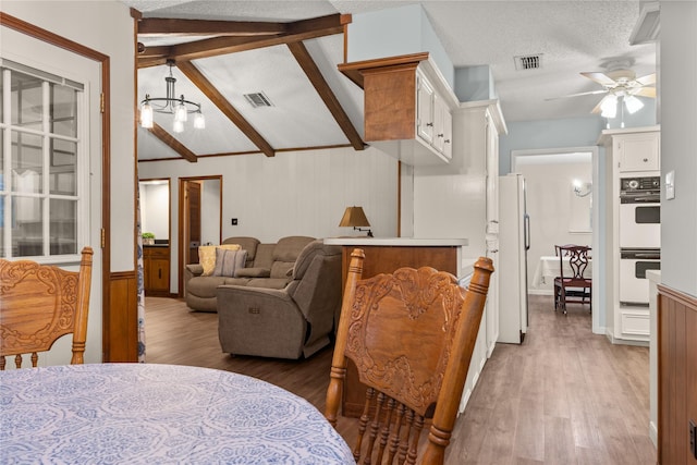 2006 Echo Ridge Ct, Houston, TX 77339 - living area with light wood finished floors, a ceiling fan, a wainscoted wall, a textured ceiling, and a chandelier