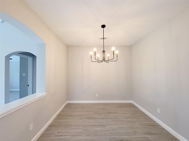 18106 Water Mill Dr, Cypress, TX 77429 - empty room featuring light wood-style floors, a chandelier, and arched walkways